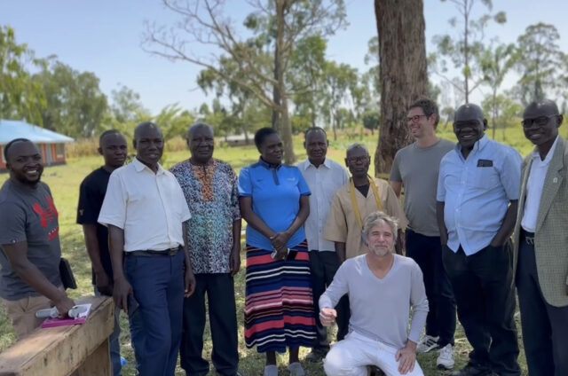 Matthias Boch and Philippe Grohe stand with Ben Koyoo, Stephen Omondi, the headteacher, and community representatives at Ralang Primary School.