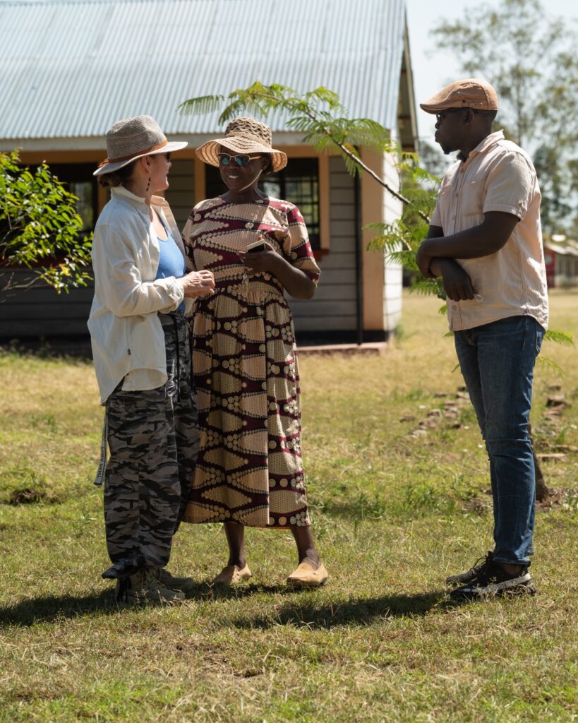 A woman in a straw hat engages in a meaningful conversation with the headteacher and a teacher of the Ngeny School for the Hearing Impaired, reflecting WellBoring’s commitment to listening and co-development.