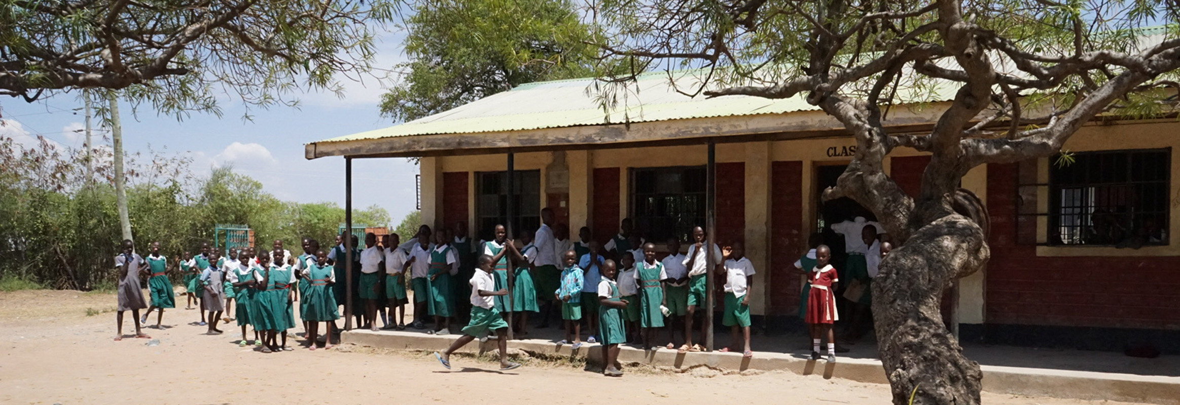 Students in green uniforms gather outside their school in Kenya, a central hub for education and community engagement thanks to reliable water access.