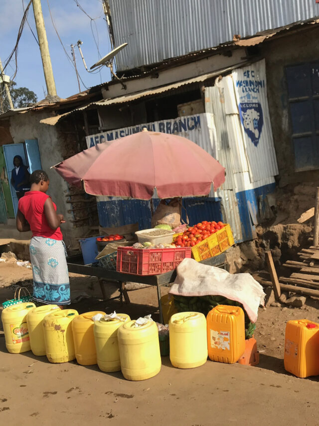 Jerrycans filled with water lined up at a rural market, highlighting the daily struggle for safe drinking water in sub-Saharan Africa.