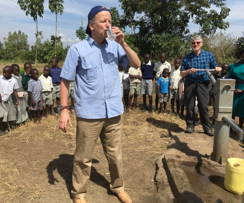 Nigel Linacre, Founder of WellBoring, sampling clean water from a school well in rural Kenya, operated by Rick Squires of Rotary.